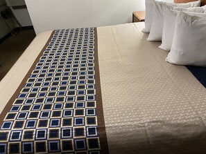 Un lit avec une couvre-lit à motifs et des oreillers.