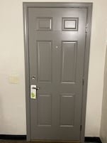 Puerta gris cerrada con letrero de privacidad y un interruptor de luz en la pared.