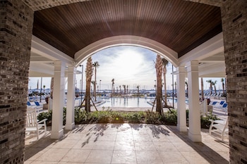 A spacious lobby with high ceilings, a grand chandelier, and a central open area leading to a door. at The Beach Club at Charleston Harbor Resort and Marina