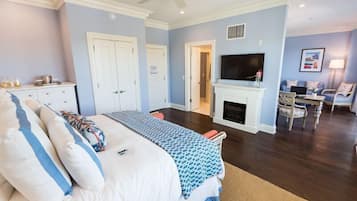 Un dormitorio con cama, televisión, chimenea y zona de estar.