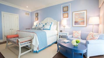 Een slaapkamer met een bed, nachtkastjes, een bank en een stoel.