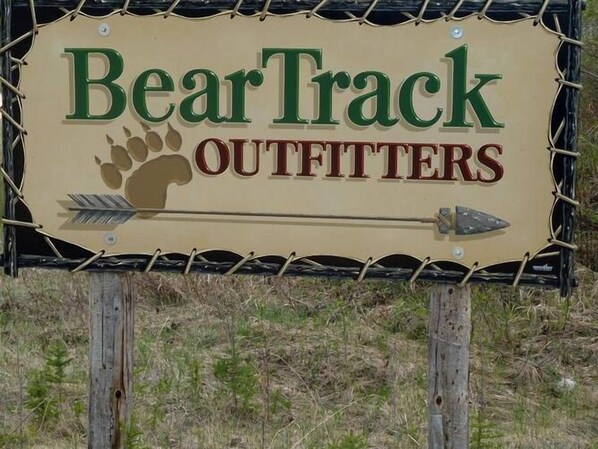 A sign for BearTrack Outfitters with a bear paw and arrows. - Bear Track Outfitters (Winnipeg)