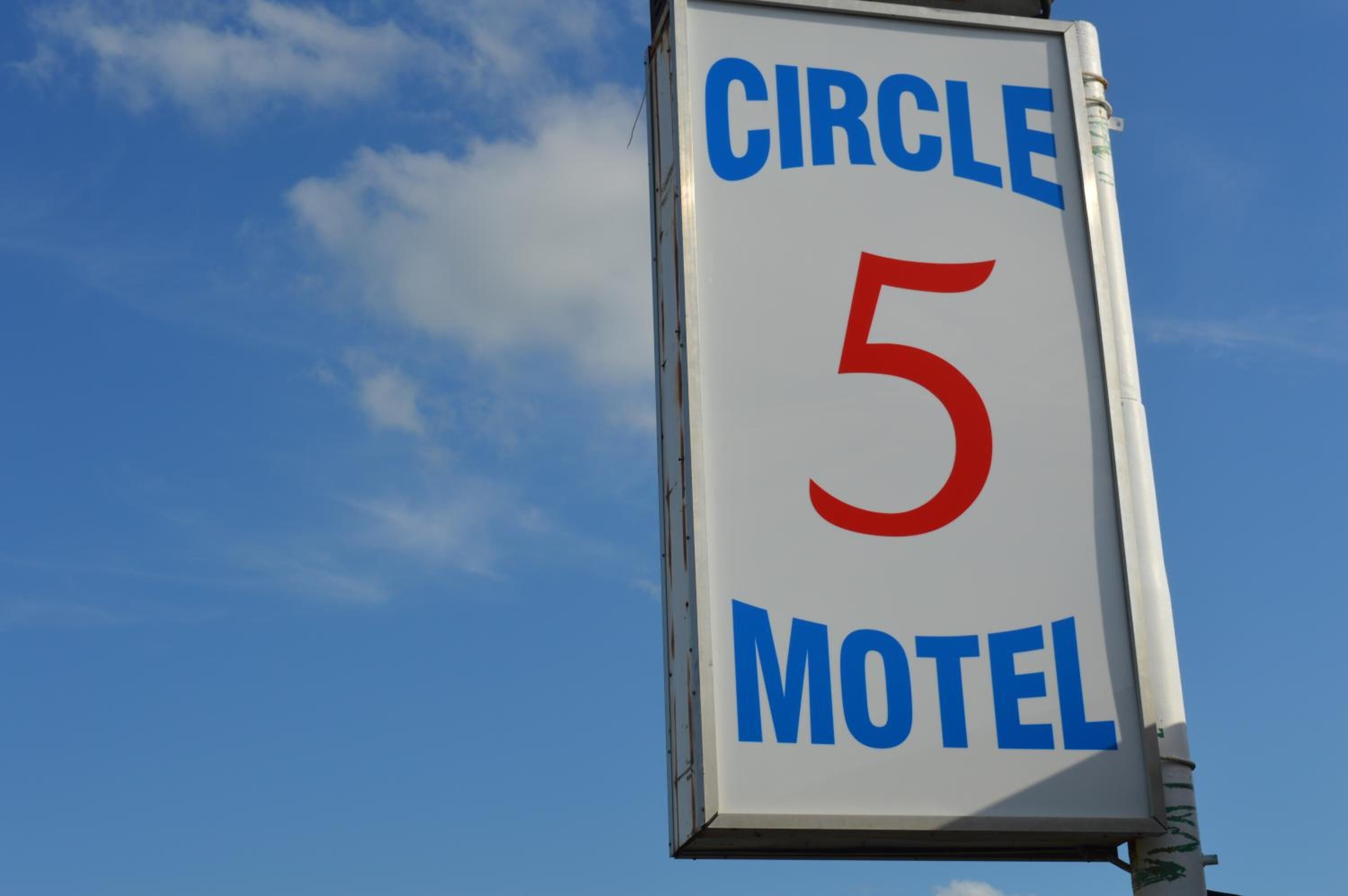 A sign for Circle 5 Motel with a clear blue sky in the background.