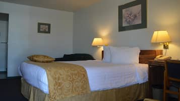 Habitación de hotel con cama, dos lámparas de noche, un teléfono, una silla y un cuadro en la pared.