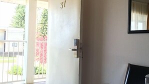 A hotel room with a door marked '31', a bed, a chair, and a small table. - Circle 5 Motel (Olds)
