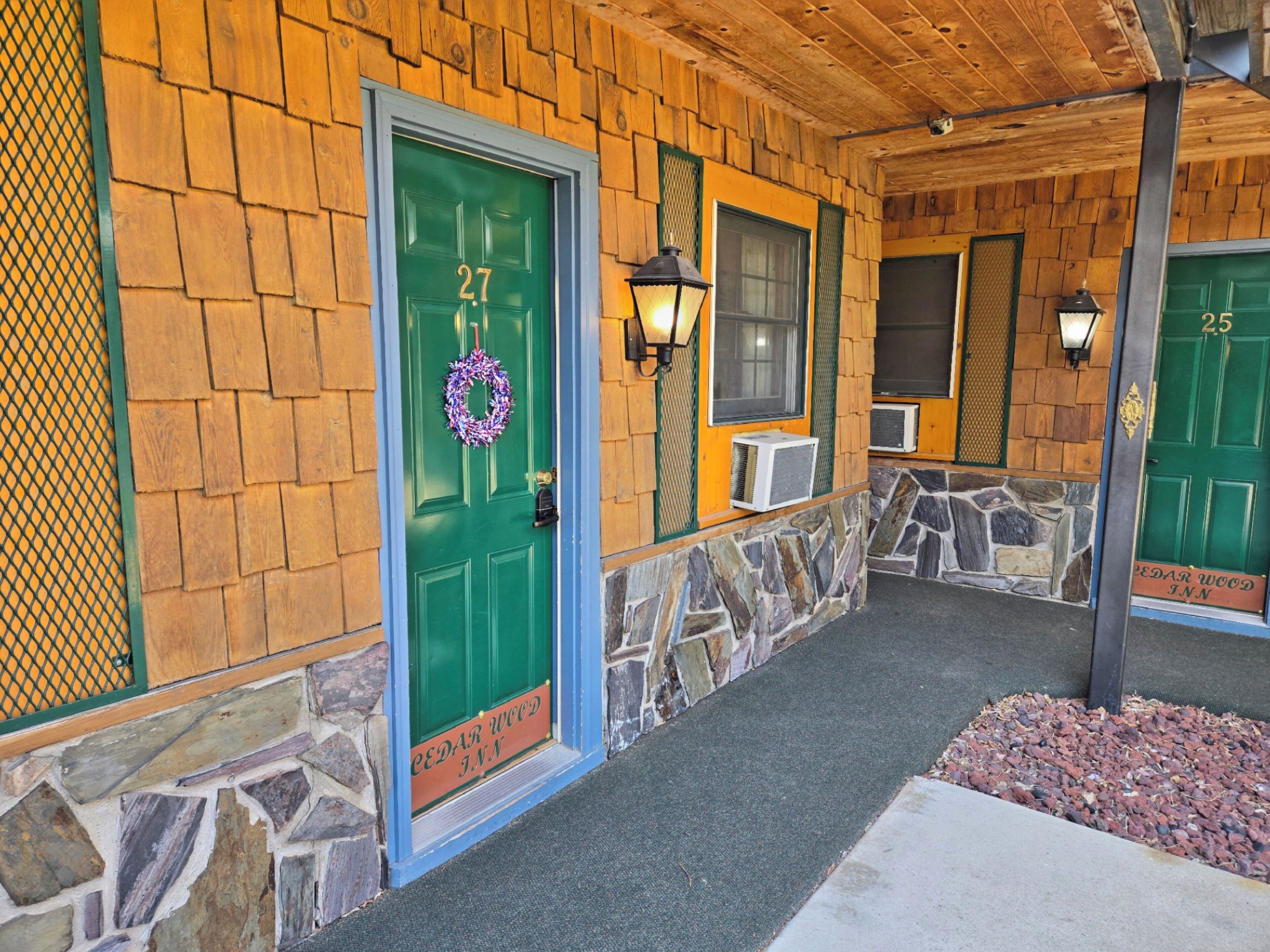 A building with a stone and wooden facade, numbered doors, and a stone pathway leading to the entrance.