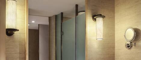 A modern bathroom with a large mirror, a vessel sink, wooden vanity, and built-in towel storage.