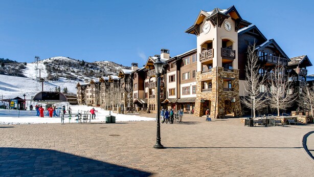 Ein Hotel mit steinverkleideter Fassade, mehreren Balkonen und einem Glockenturm.