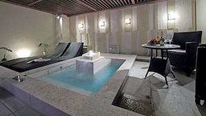 A spa area with a hot tub, lounge chairs, and a table with drinks. - Design Hotel W Zip Club - Adults Only (Nagoya)