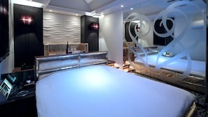 A modern hotel room with a large bed, a desk with a control panel, and a glass partition with decorative elements. - Design Hotel W Zip Club - Adults Only (Nagoya)