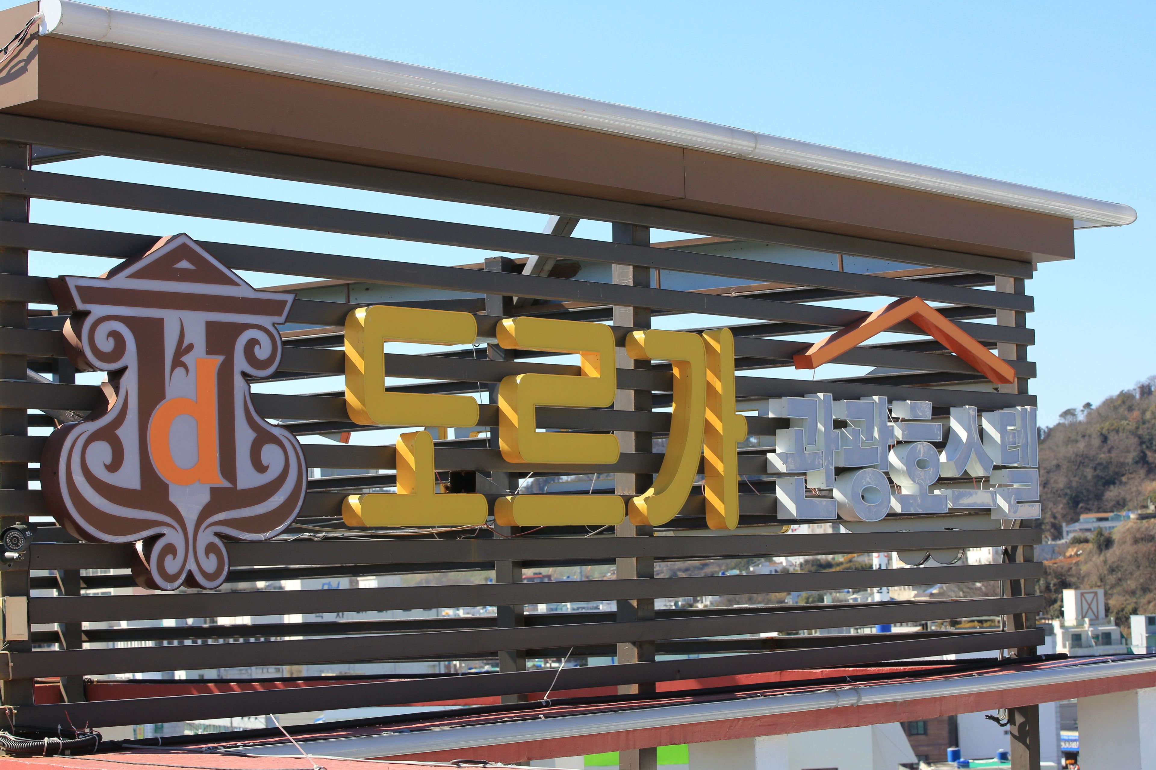 A sign with Korean text and a logo, indicating a business or establishment.