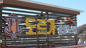A sign with Korean text and a logo, indicating a business or establishment.