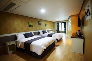 Ett hotellrum med två sängar, ett litet skrivbord och en tv.