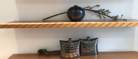Una estantería con jarrones decorativos y ramas.