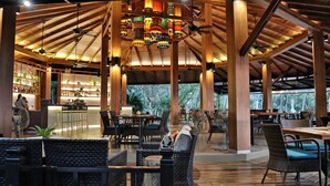 A spacious indoor area with high ceilings, wooden beams, and multiple seating arrangements.