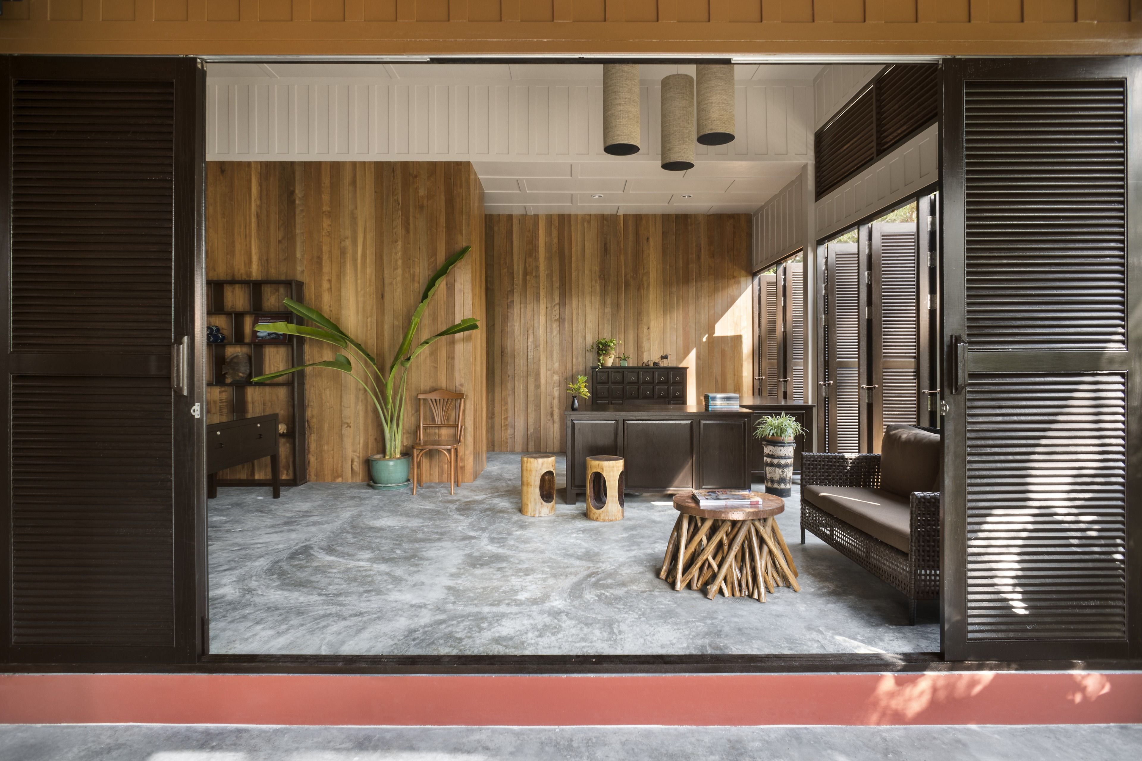Une pièce avec un mur en bois, un canapé, une table basse et une plante en pot.