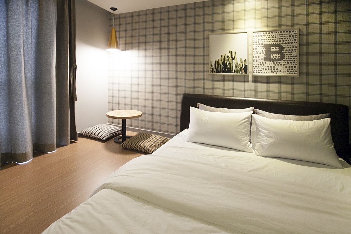 A hotel room with a large bed, a small round table, and a wall-mounted artwork.