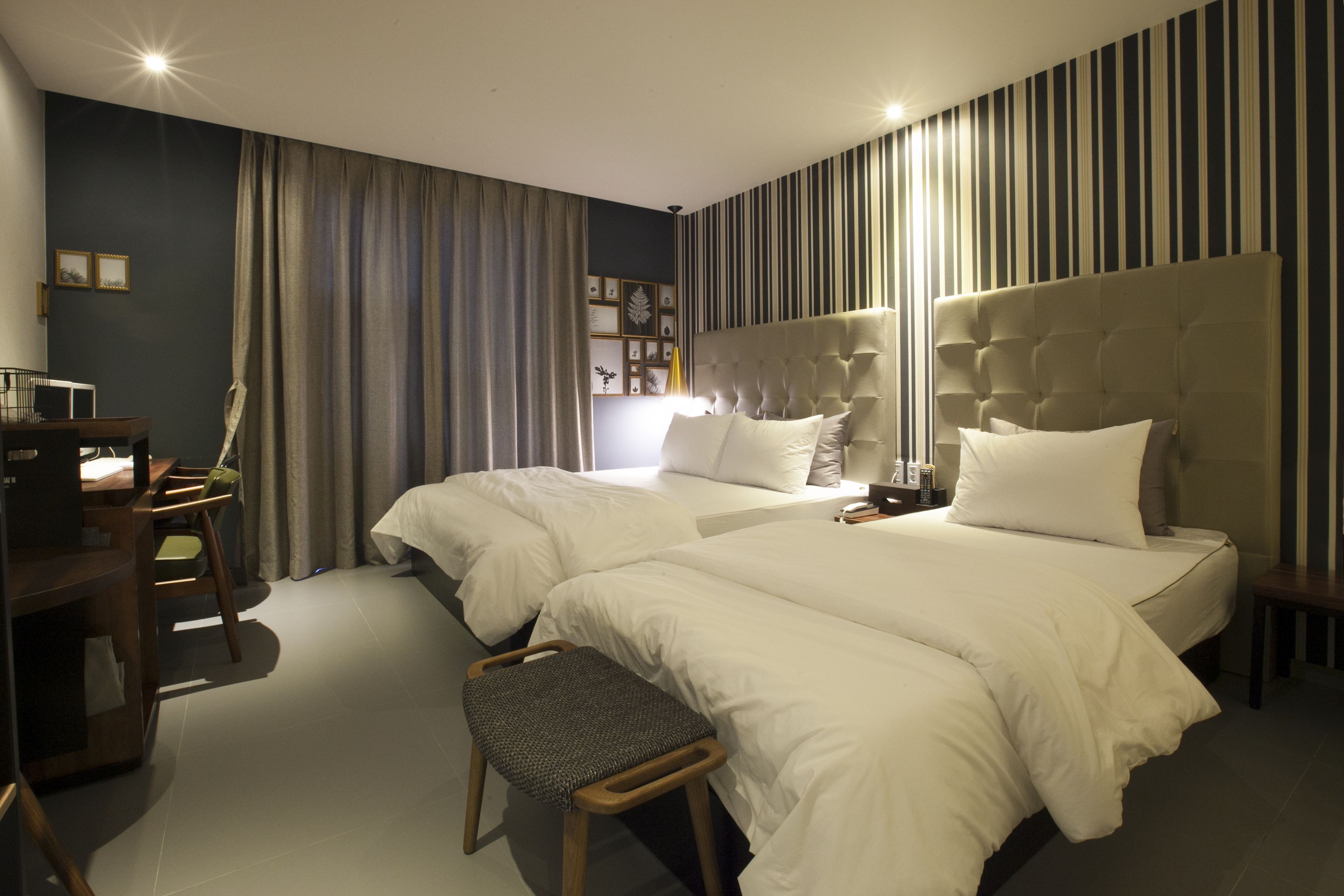 Una habitación de hotel moderna con dos camas, un escritorio y una silla.