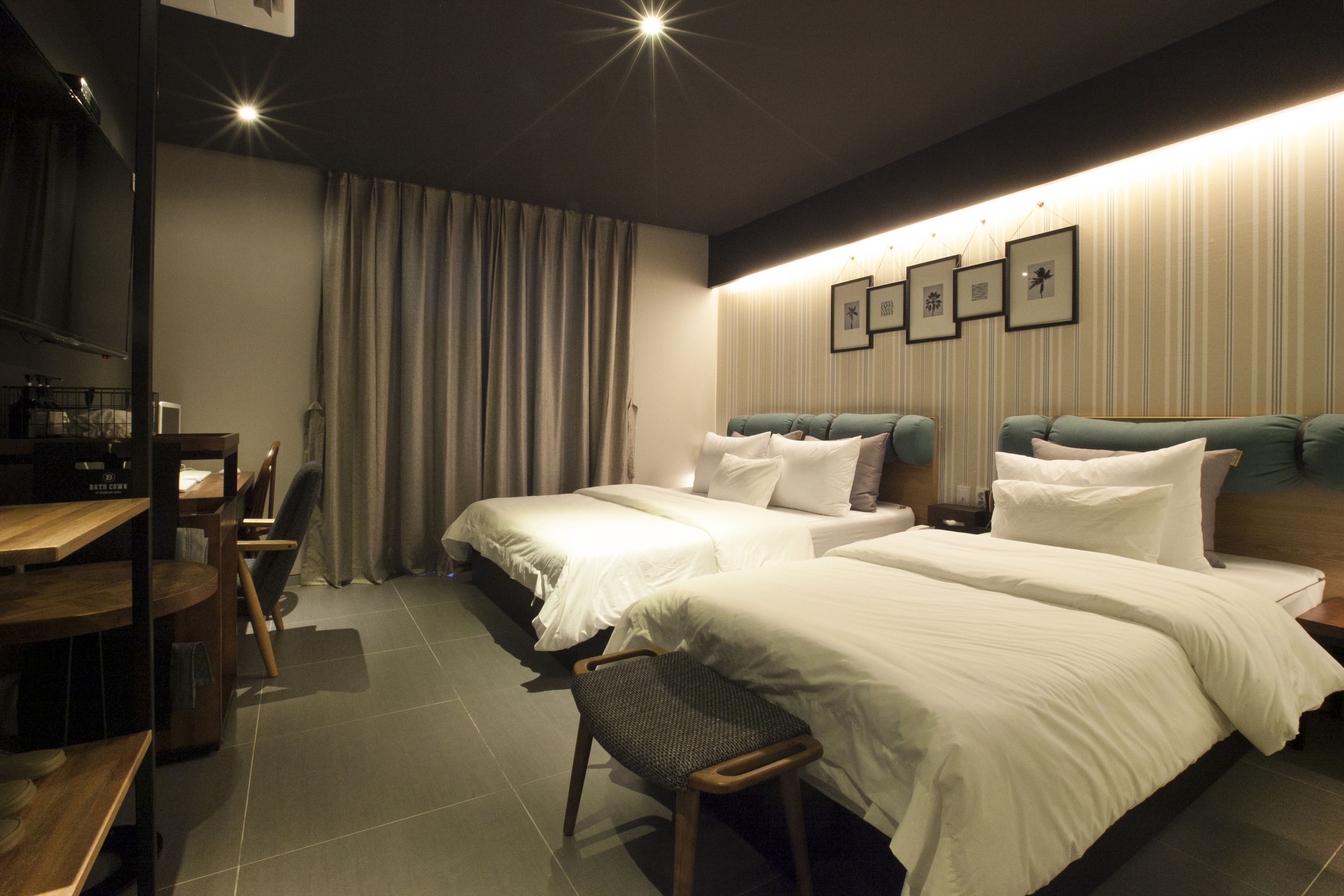 A hotel room with two beds, a desk, and a chair.
