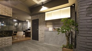 Un interior moderno con una recepción, una zona de estar y una planta en maceta.