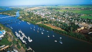 An aerial view of a coastal town with a marina, a bridge, and residential areas. - AAOK Riverdale Caravan Park (Bundaberg North)