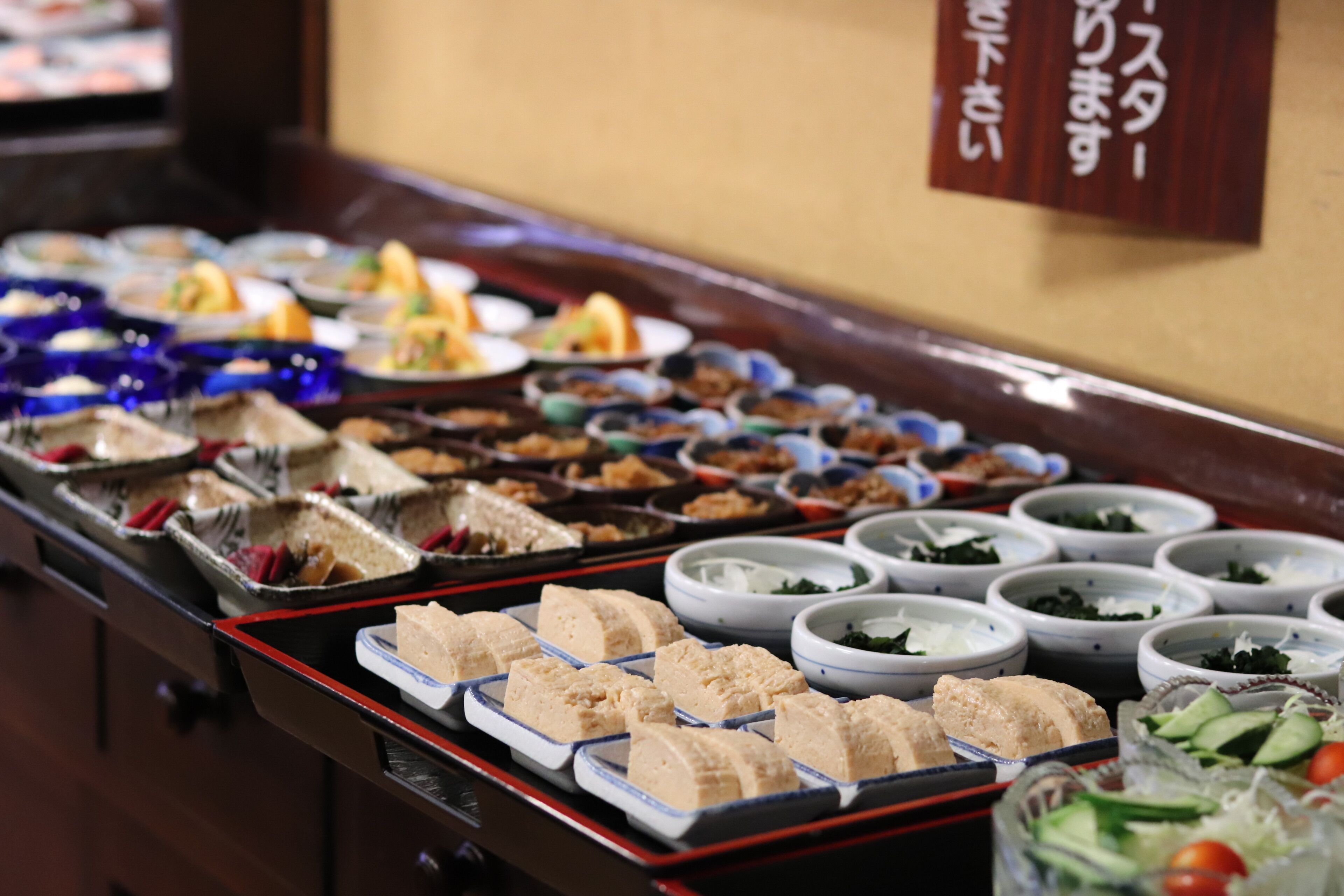 A buffet with various dishes and bowls of food.