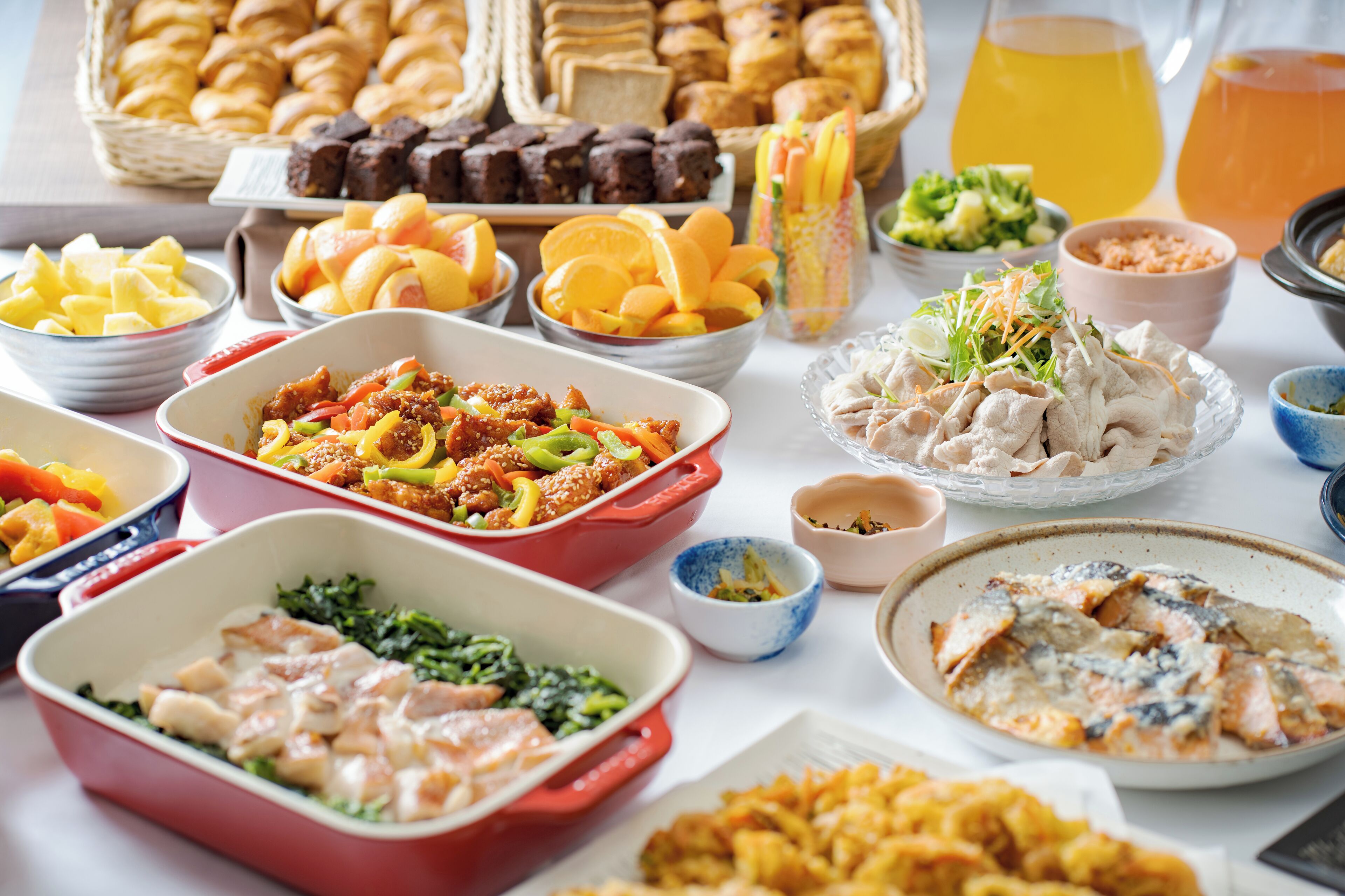 A buffet with various dishes including meats, salads, and pastries.