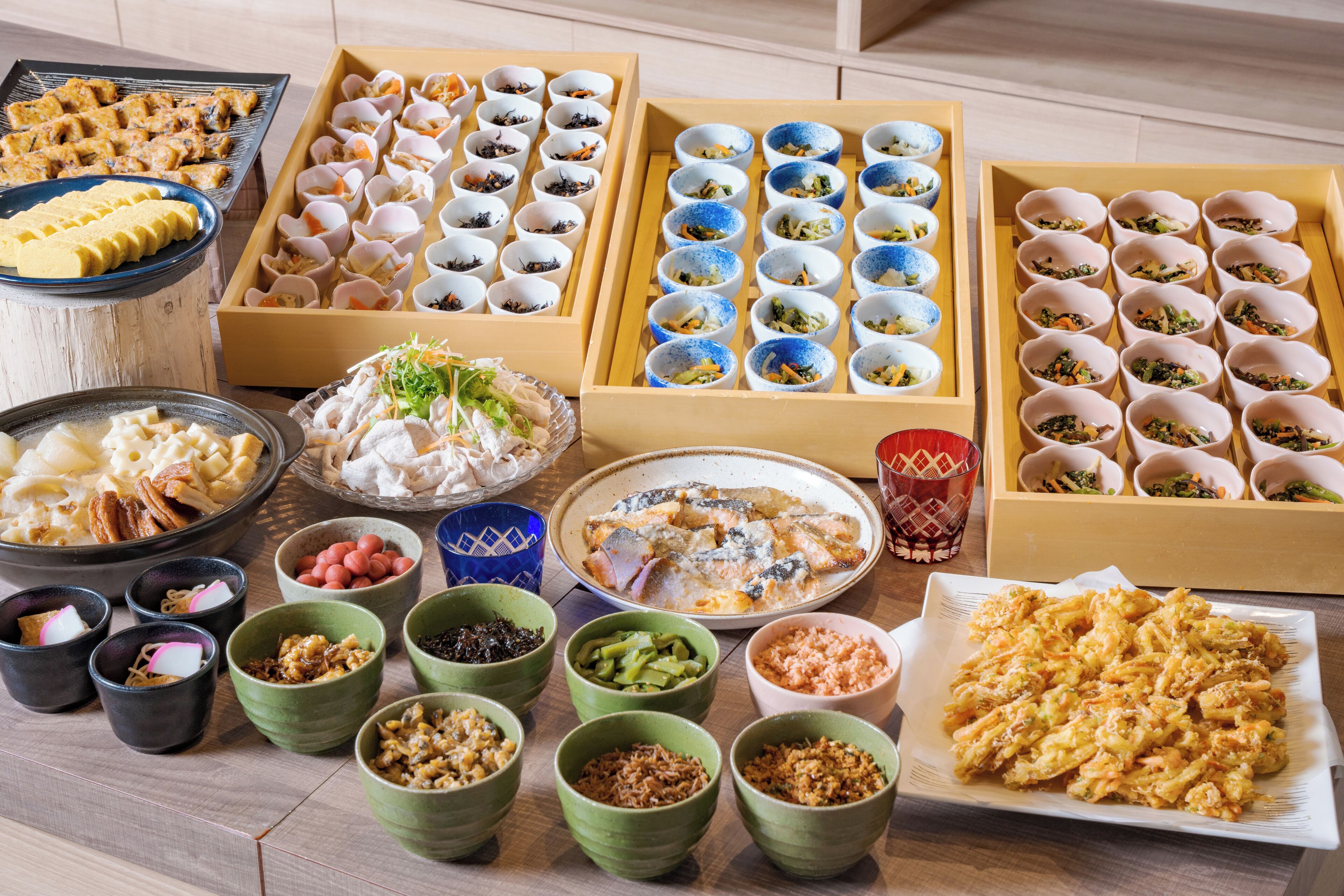 Diversos alimentos presentados sobre una mesa, incluyendo cuencos, platos y fuentes con distintos platillos.
