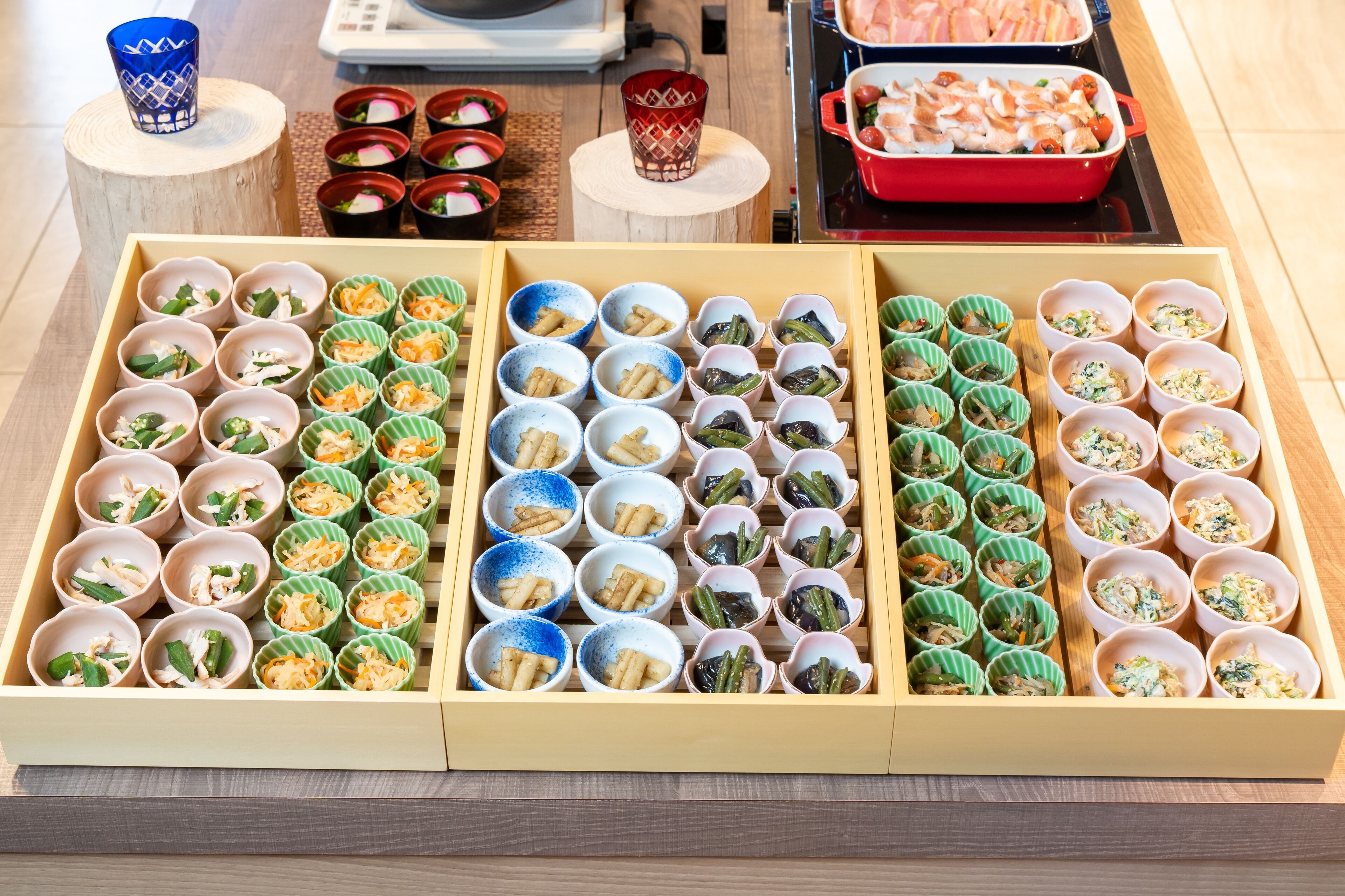 A wooden tray with multiple compartments containing various food items.