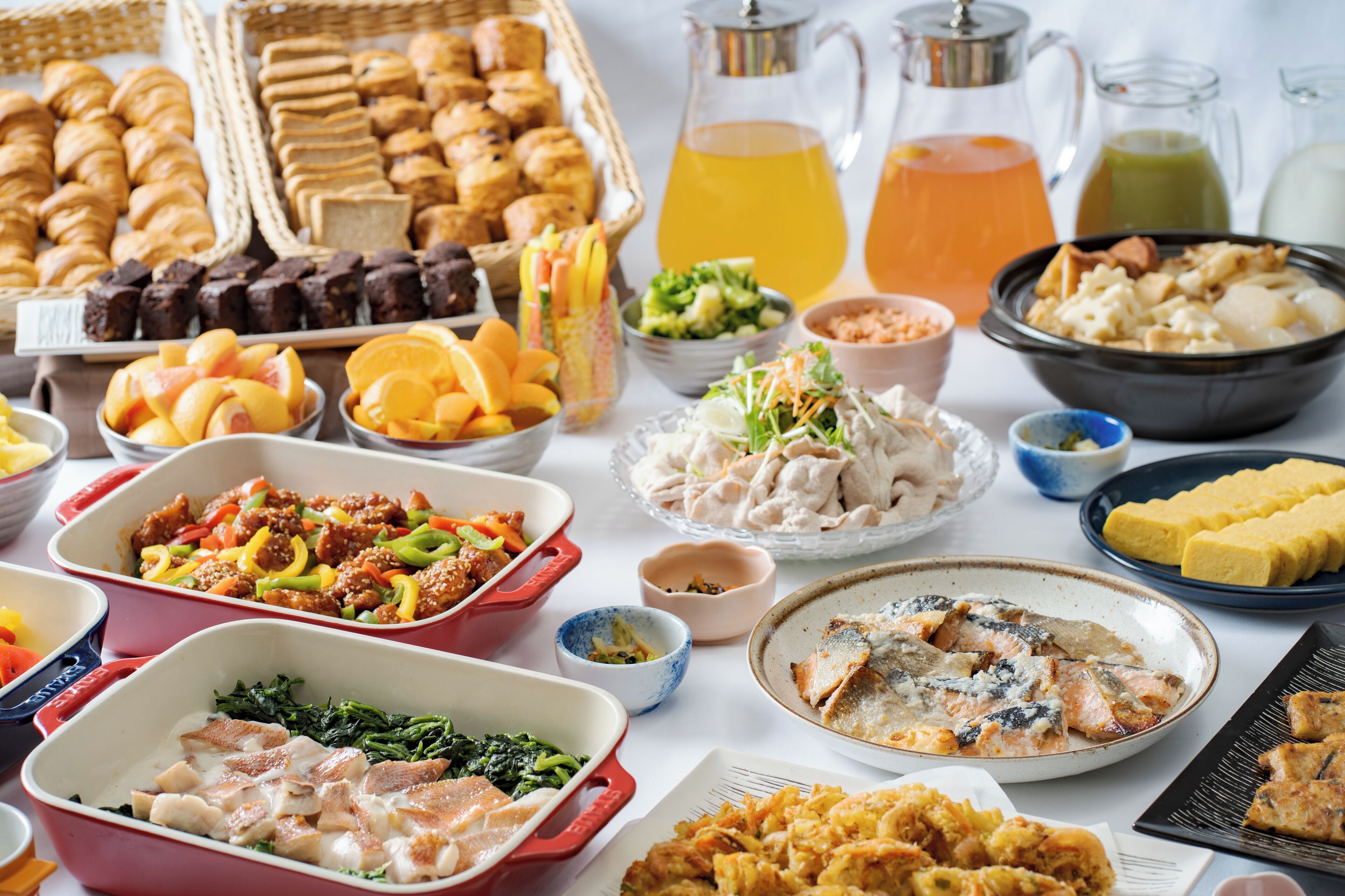 Una mesa con diversos platos, incluyendo carnes, verduras y pasteles.