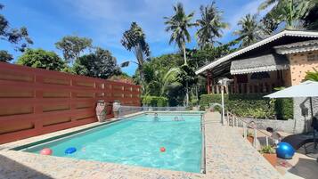 Una piscina al aire libre, tumbonas