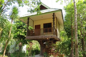A treehouse with a balcony, surrounded by lush greenery. - Macura Resort (Ko Chang)