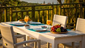 A table set for breakfast with plates, bowls, and a fruit basket. - Lofos Soilis (Zakynthos)