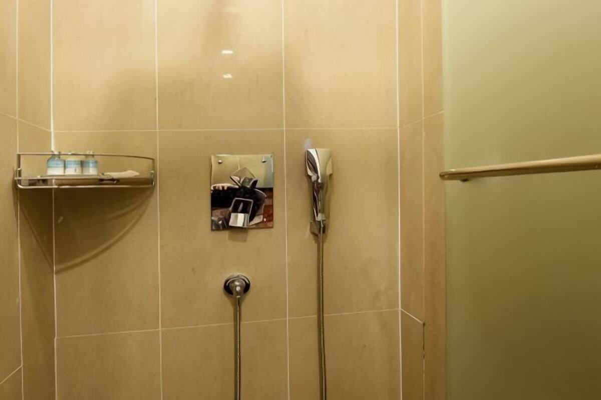 A bathroom with a shower, a towel rack, and a soap dish.