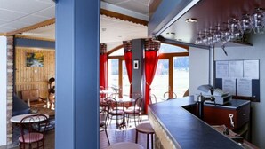 A bar area with a counter, chairs, and a view of the outside.