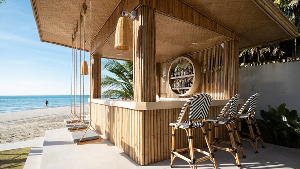 Een strandbar met bamboemeubels en een ronde bar.