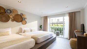 Ein Hotelzimmer mit zwei Betten, einem Balkon und einem Fernseher auf einem Holztisch.