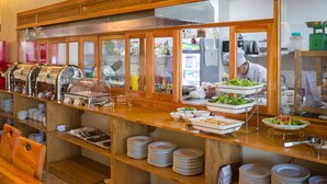 Montaje de bufé con varias estaciones de servicio, que incluyen ensaladas, sándwiches y platos calientes.