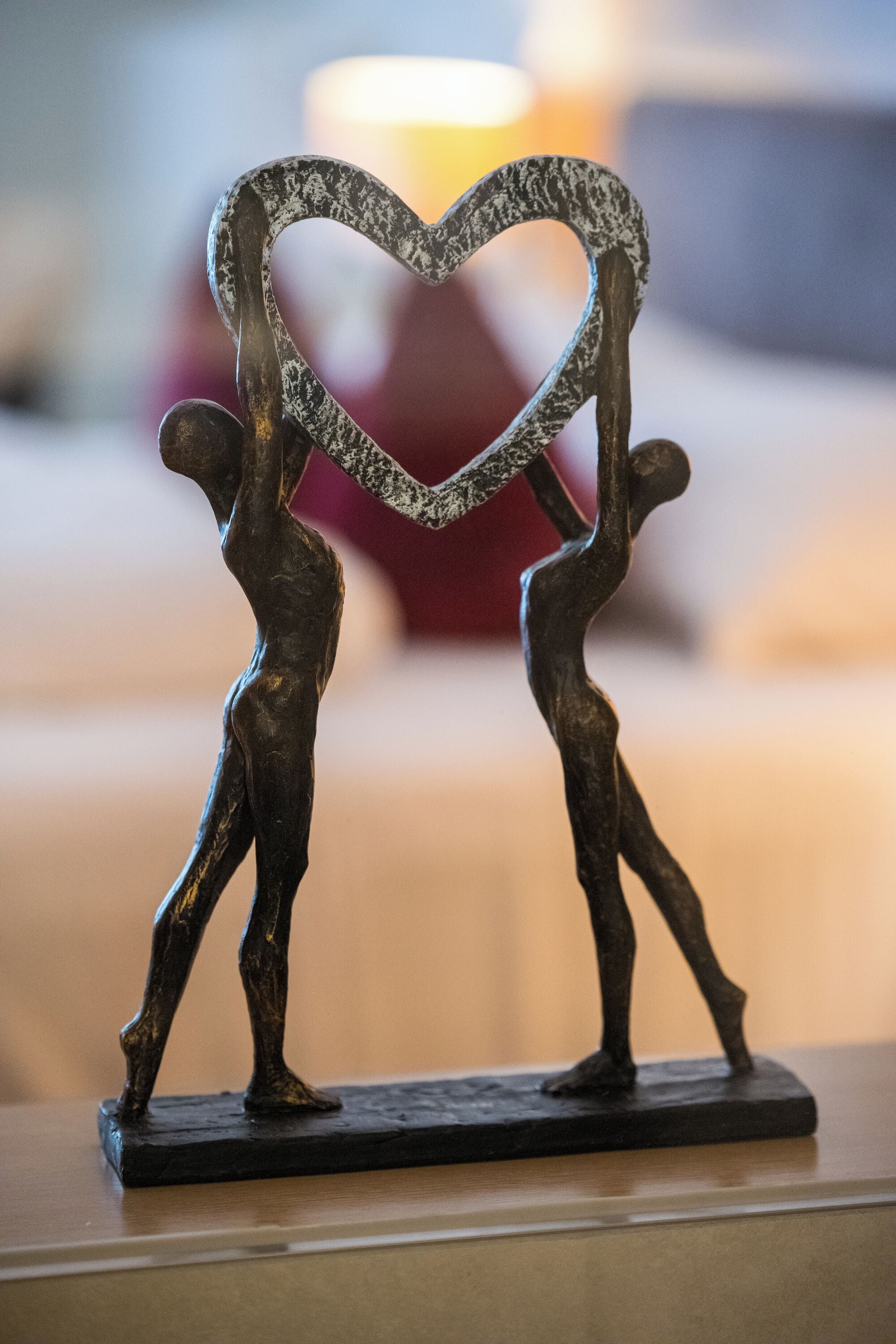 A sculpture of two figures holding a heart-shaped object.