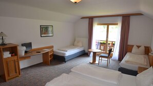 A hotel room with a bed, a desk, a chair, and a small table. - Alpenhotel Widderstein (Mittelberg)