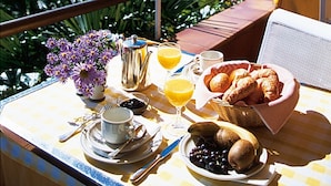Una mesa lista para el desayuno con vistas a un paisaje montañoso y una piscina.