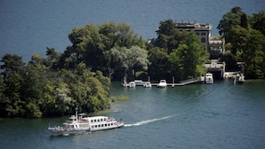 Un bote en un río con un muelle y edificios al fondo.