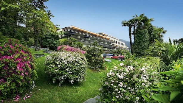 Un hotel de diseño moderno, con un patio central repleto de vegetación exuberante y plantas en flor.