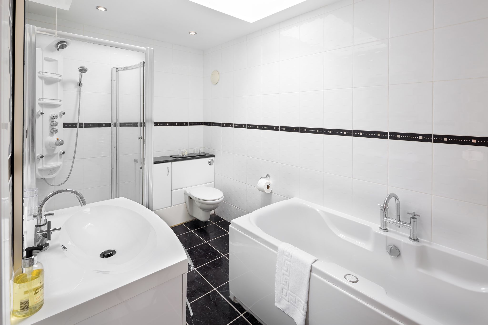 A modern bathroom with a white sink, toilet, and bathtub.