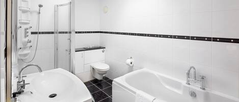 A modern bathroom with a white sink, toilet, and bathtub.