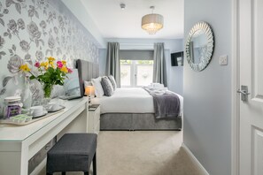 A bedroom with a bed, bedside table, lamp, and a window with curtains. - The Coppice Guest House (Windermere)