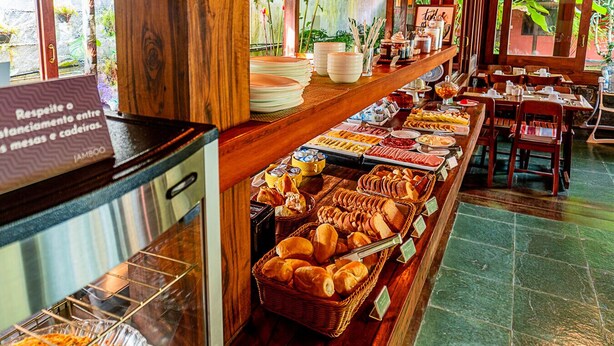 A buffet with various food items and a sign about respecting the space between tables. - Pousada Jamboo (Ubatuba)