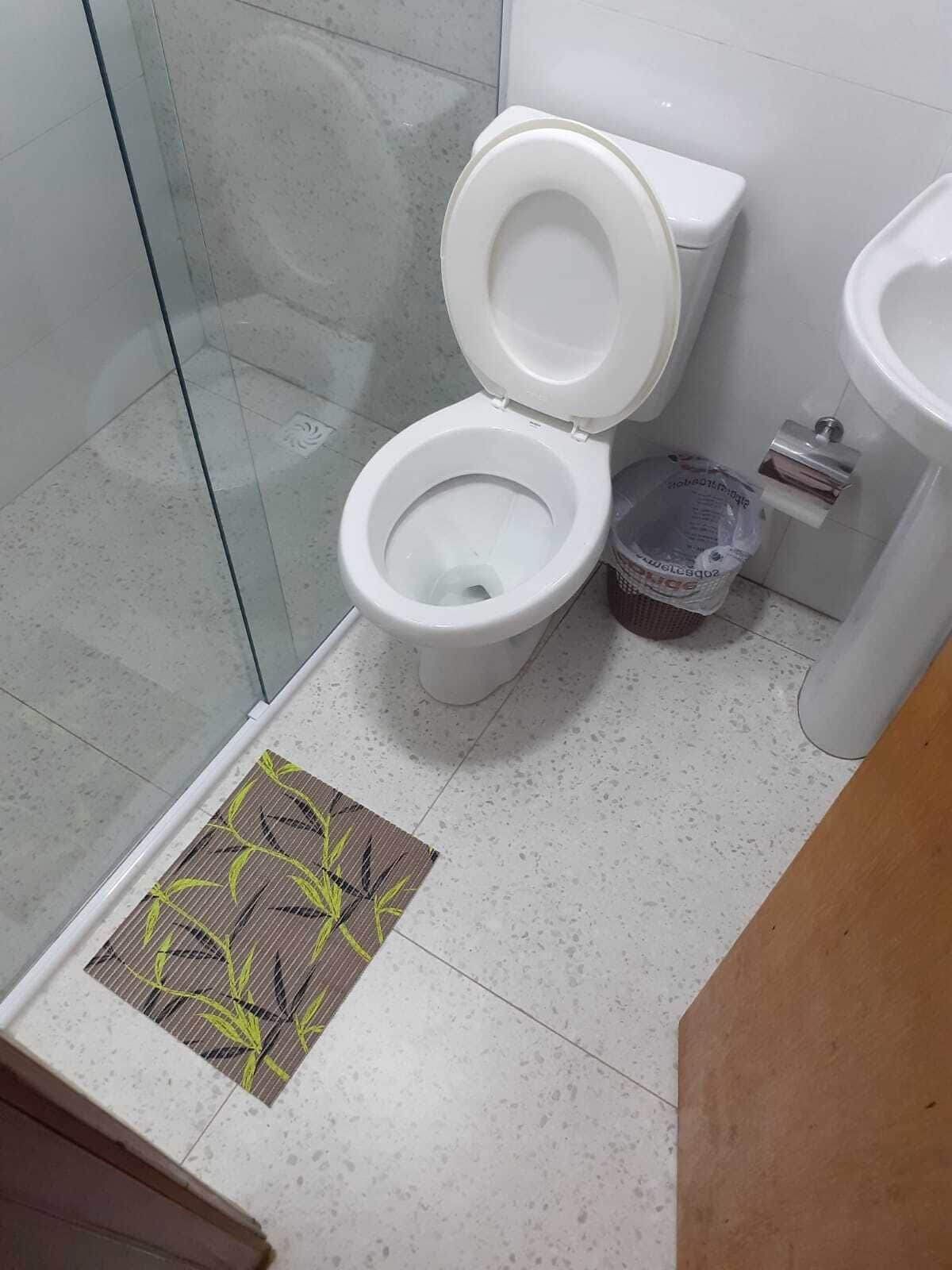 Une salle de bain équipée de toilettes, d’un bidet et d’une poubelle.
