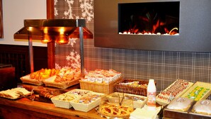 Un bufé con diversos alimentos y una pared decorativa con chimenea.