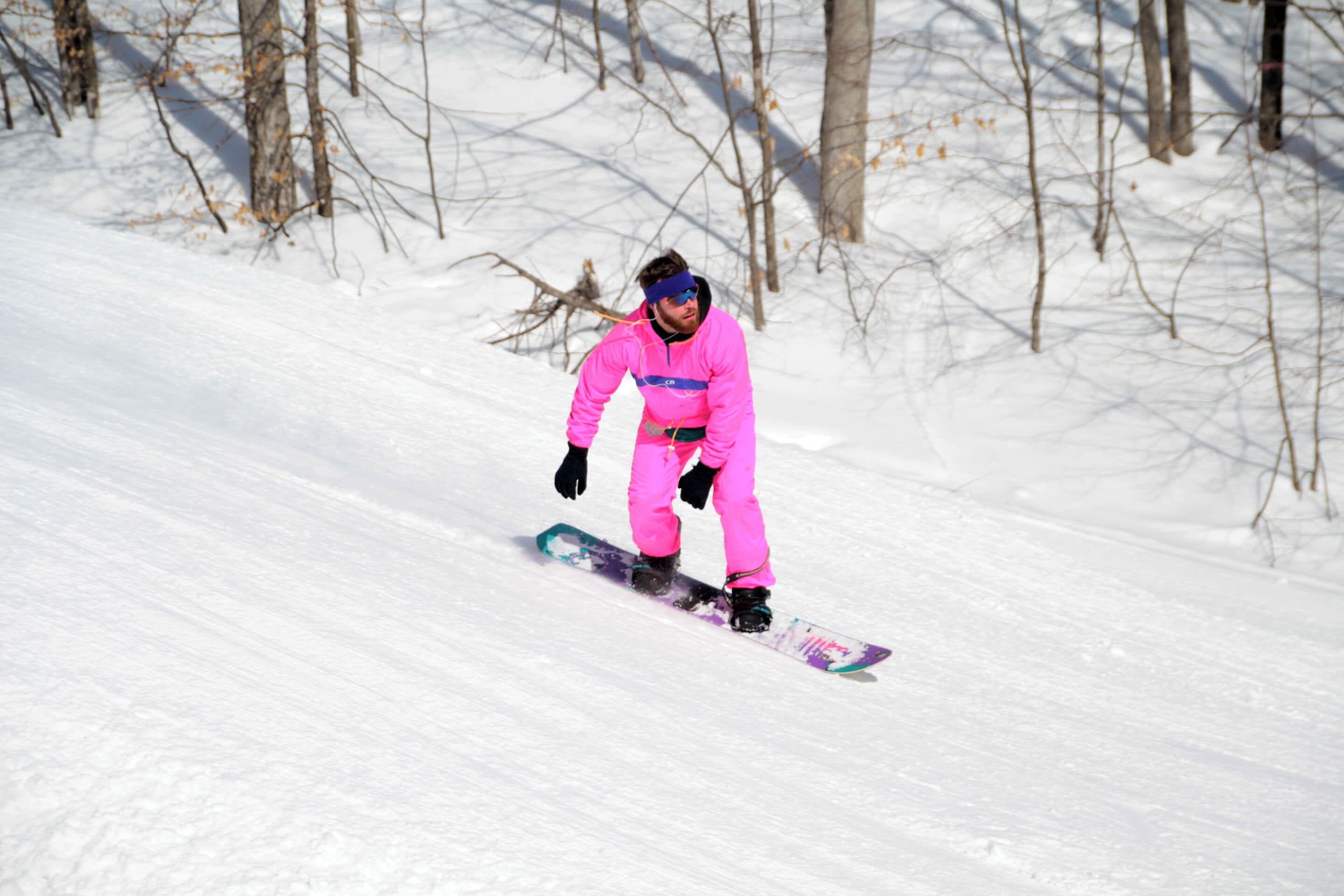 Una persona haciendo snowboard por una pendiente nevada.